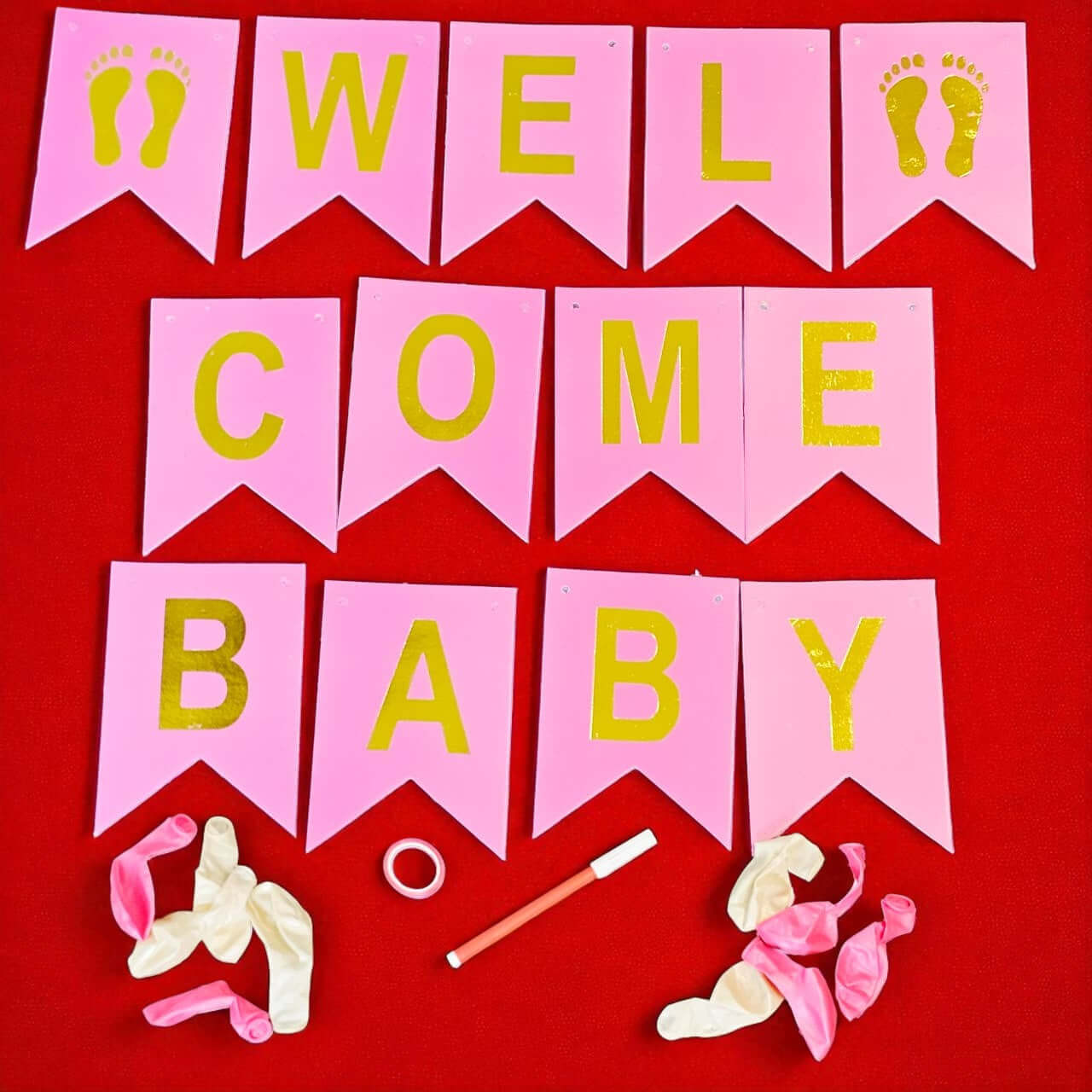 Pink and yellow 'Welcome Baby' banner with baby shower decorations on a red background