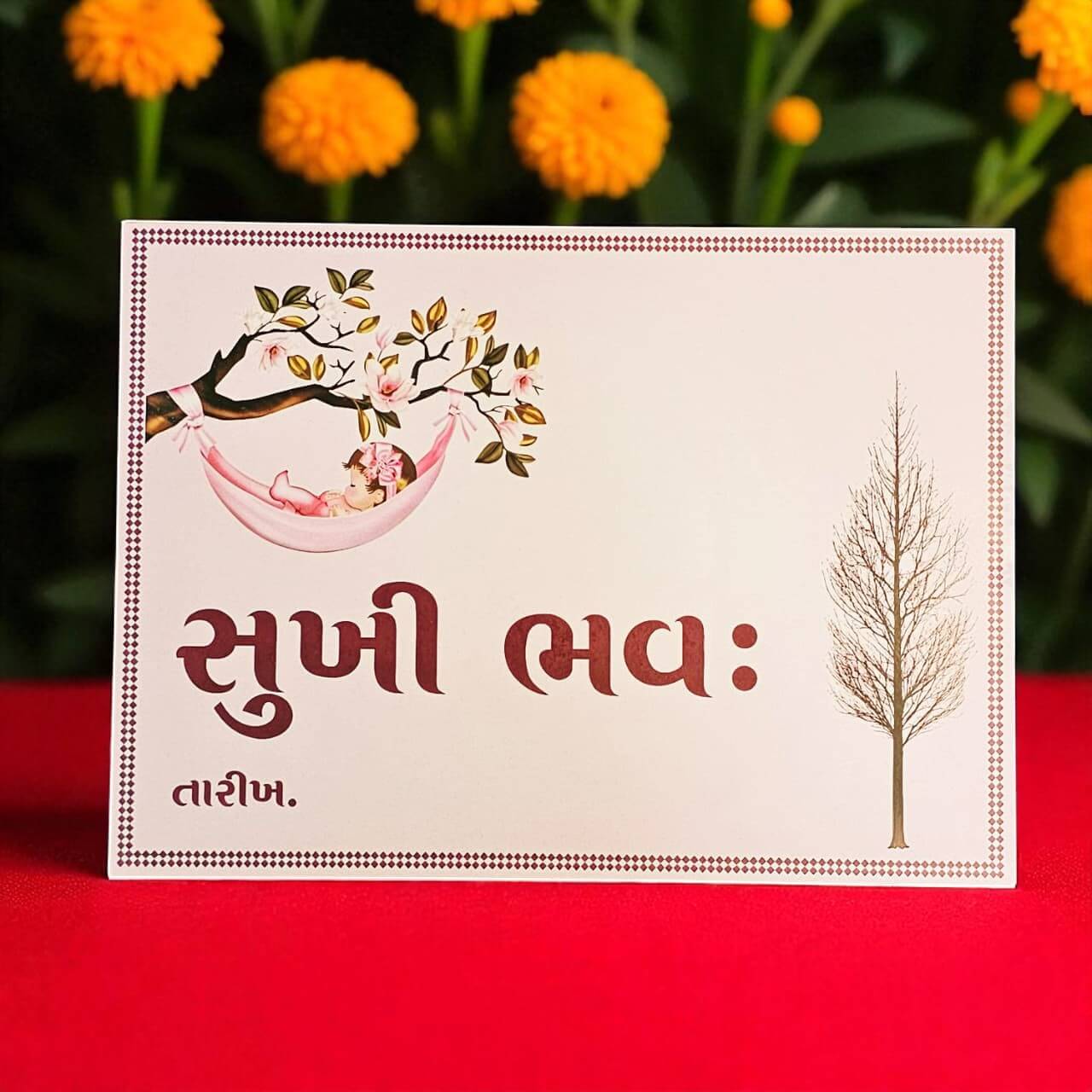 Greeting card with tree and baby illustration on a red background with marigold flowers.