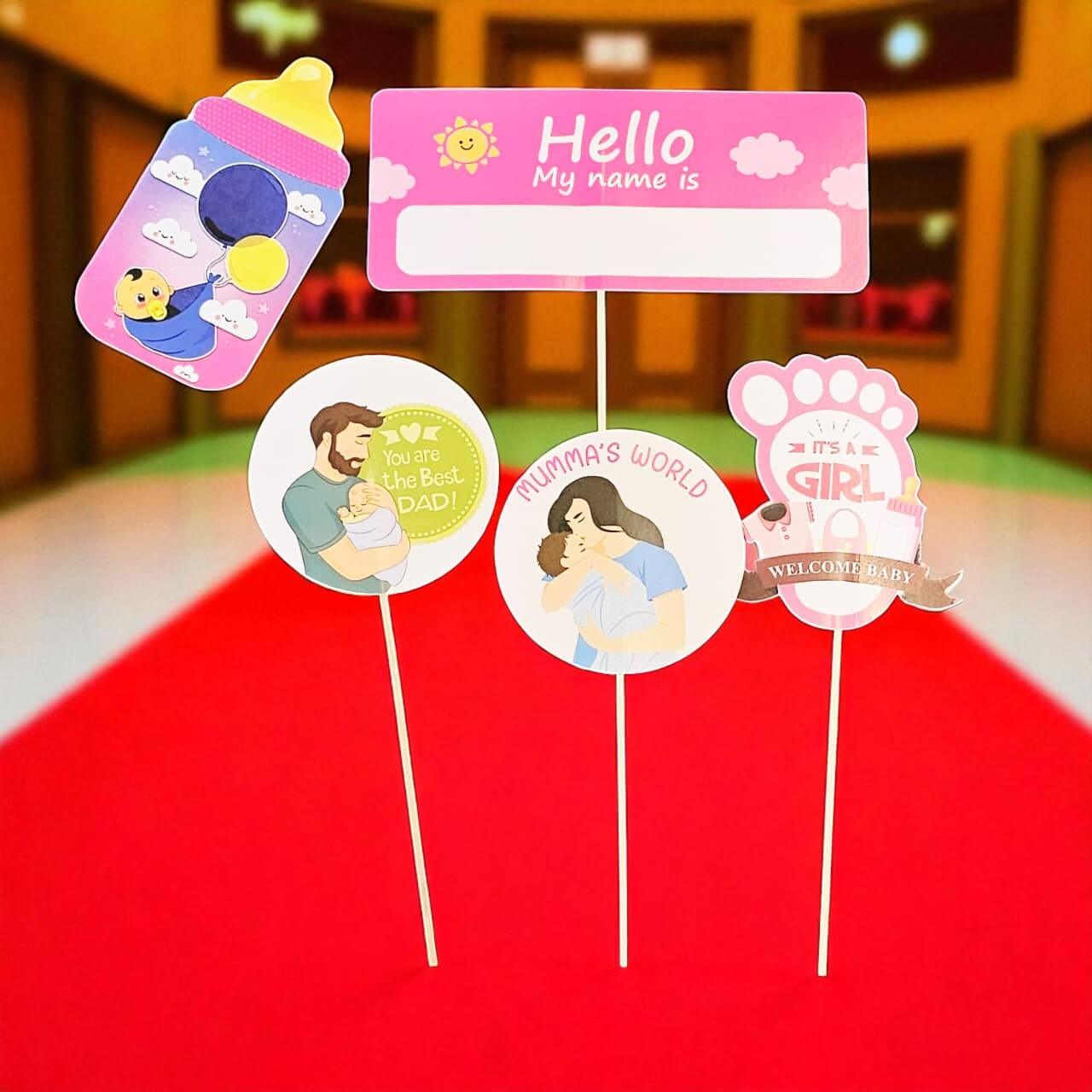 Set of baby-themed name tags on sticks with illustrations and text.