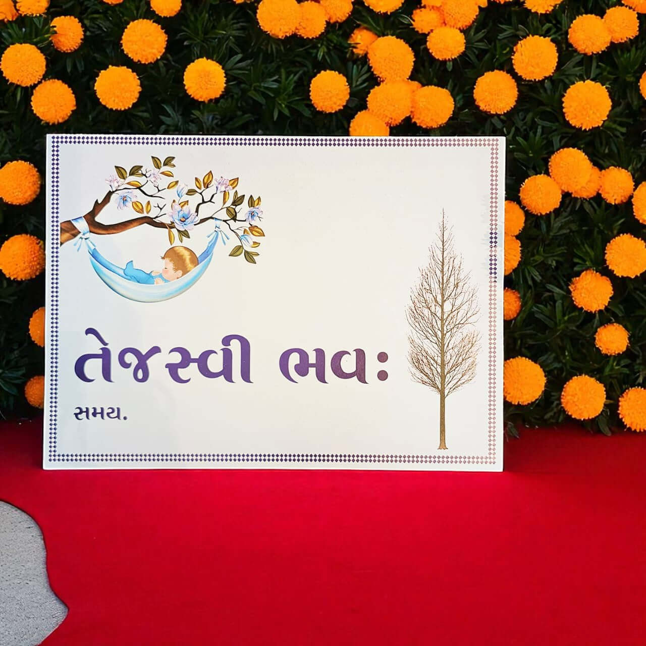 White card with tree illustration and text on a red surface with orange flowers