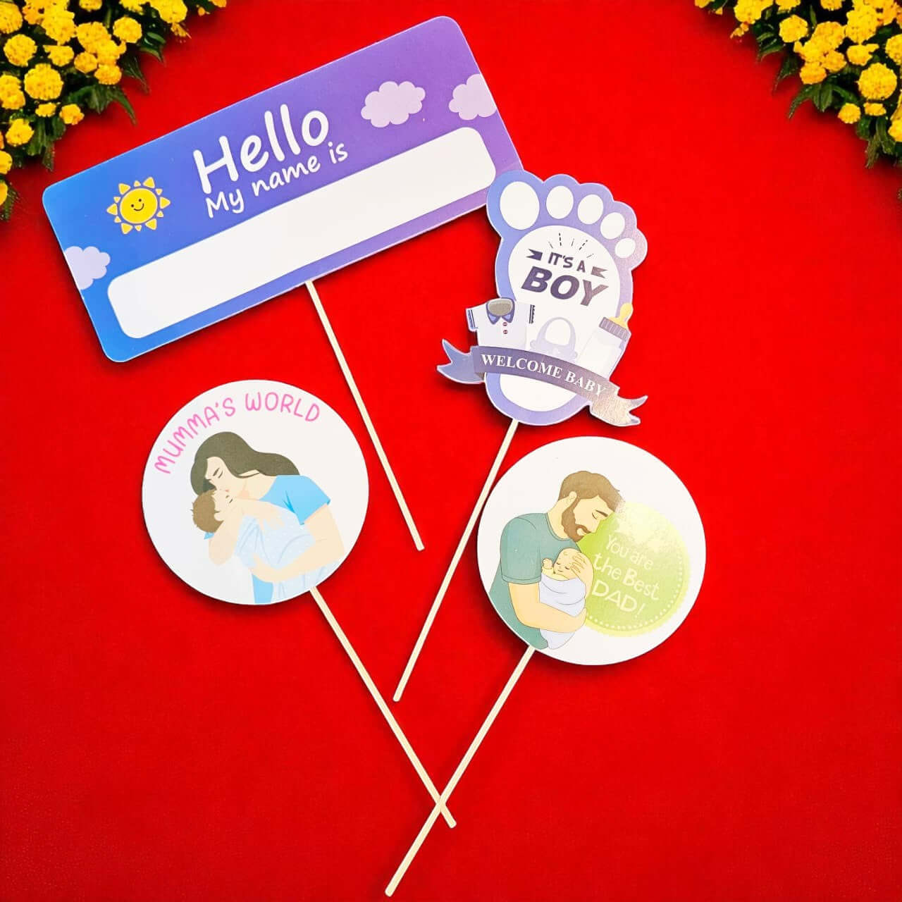 Set of baby-themed photo booth props on a red background with yellow flowers.