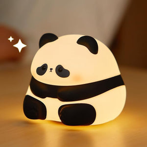 Adorable glowing white and black silicone night lamp for kids, shaped like a baby sitting panda with a sweet expression. Provides a soft, comforting light for bedrooms from uSmile.toys www.usmile.toys