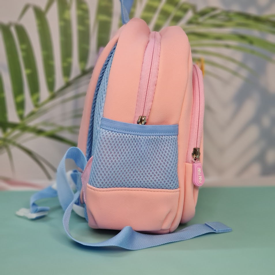 Small light pink kids' backpack with light blue dinosaur applique featuring yellow spikes, white teeth, and playful detailing on the front pocket. Embroidered above the dinosaur is the phrase "My Funny Dino" in light blue cursive. The backpack includes light blue adjustable shoulder straps and trim, ideal for toddlers or preschool children, perfect for school, travel, or gifting
