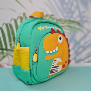 Small, teal backpack for children featuring a large orange dinosaur applique with red spikes and white teeth on the front pocket. Above the dinosaur is embroidered teal cursive text that reads "My Funny Dino". The backpack has yellow straps and yellow mesh side pockets