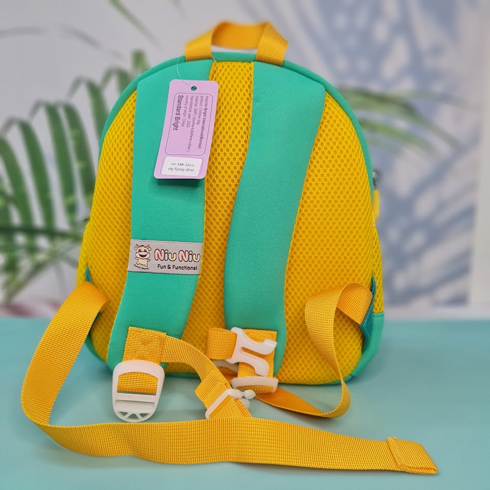 Small, teal backpack for children featuring a large orange dinosaur applique with red spikes and white teeth on the front pocket. Above the dinosaur is embroidered teal cursive text that reads "My Funny Dino". The backpack has yellow straps and yellow mesh side pockets