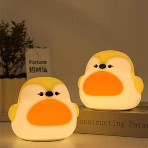 Two adorable glowing yellow and white silicone night lamps for kids, shaped like cute, plump birds or chicks with orange beaks. Ideal for a soft, comforting bedroom light from uSmile.toys." www.usmile.toys