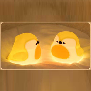 Two adorable glowing yellow and white silicone night lamps for kids, shaped like cute, plump birds or chicks with orange beaks. Ideal for a soft, comforting bedroom light from uSmile.toys." www.usmile.toys