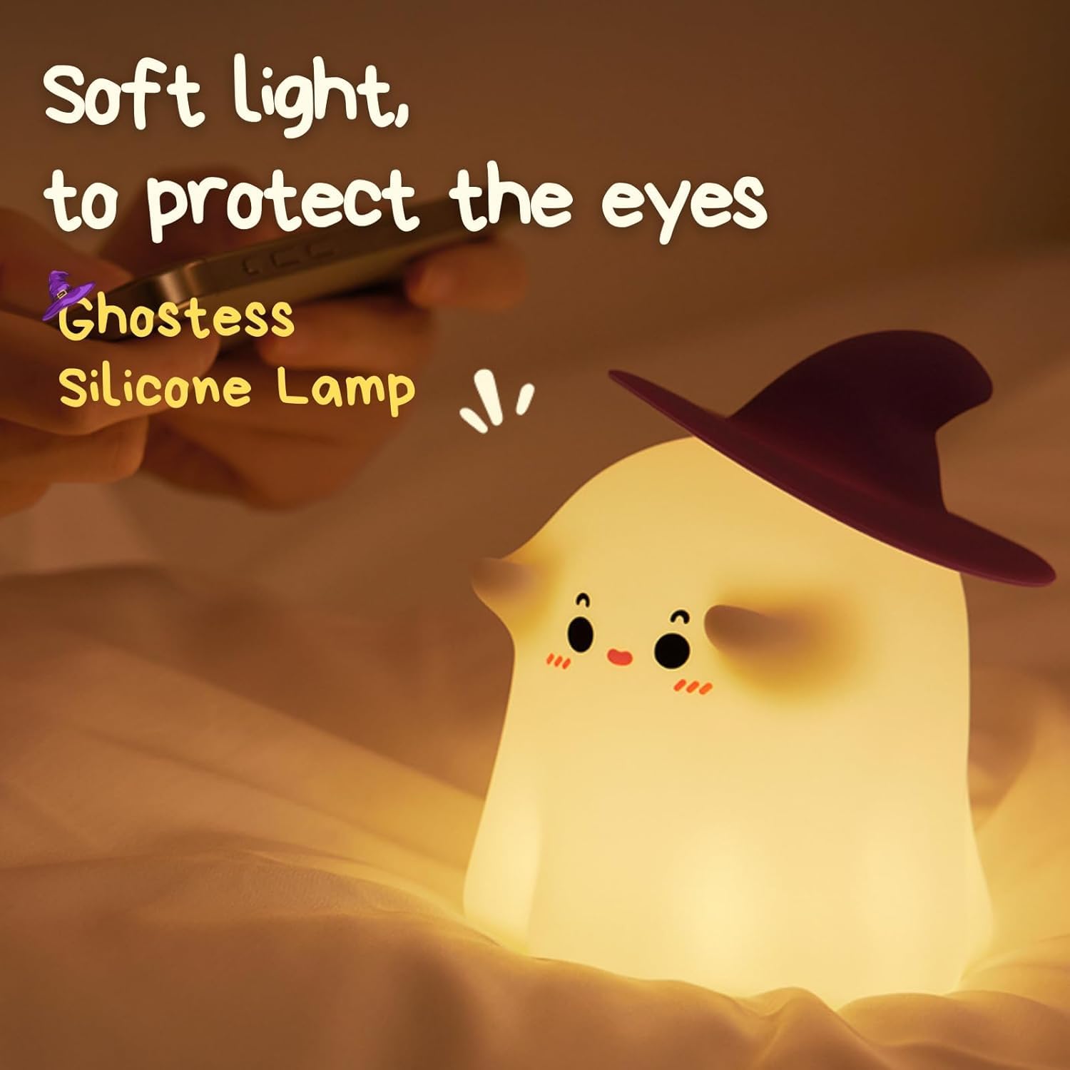 Adorable glowing white silicone night lamp for kids, shaped like a cute ghost wearing a black witch's hat, with subtle facial features. Provides a soft, comforting light. From uSmile.toys." www.usmile.toys