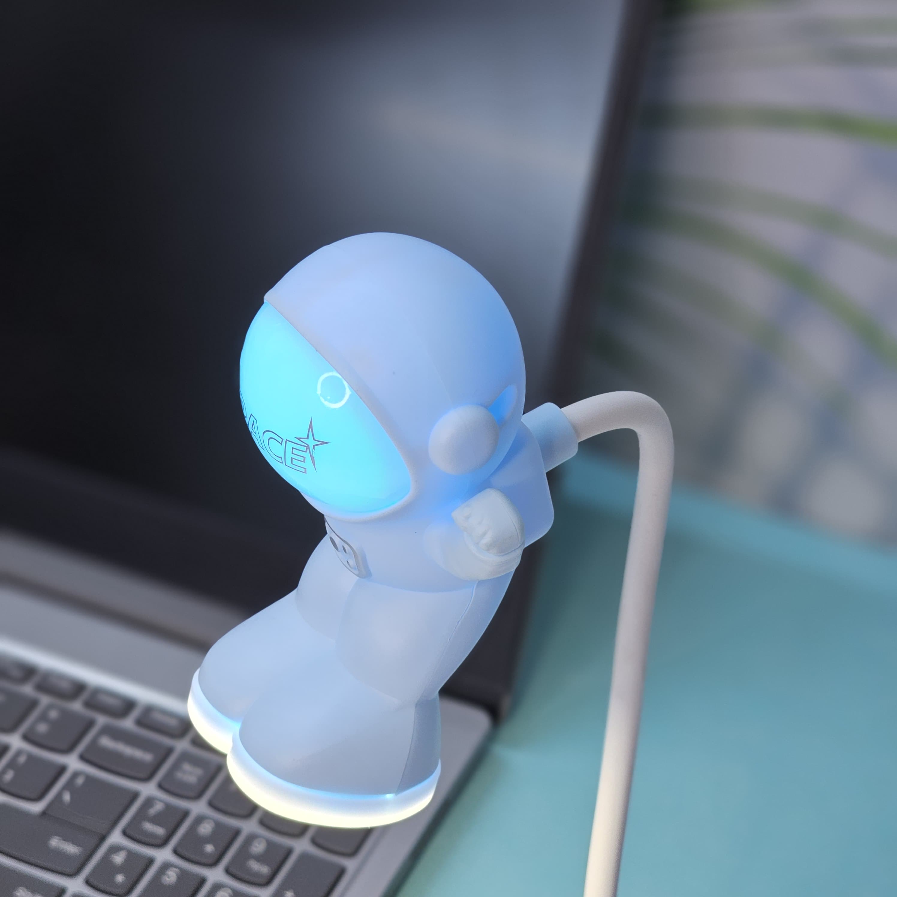 Interactive space-themed lamp for kids: a Usmile Toys astronaut figure attached to a vibrant, illuminated planet base, bringing a celestial glow to any desk." www.usmile.toys