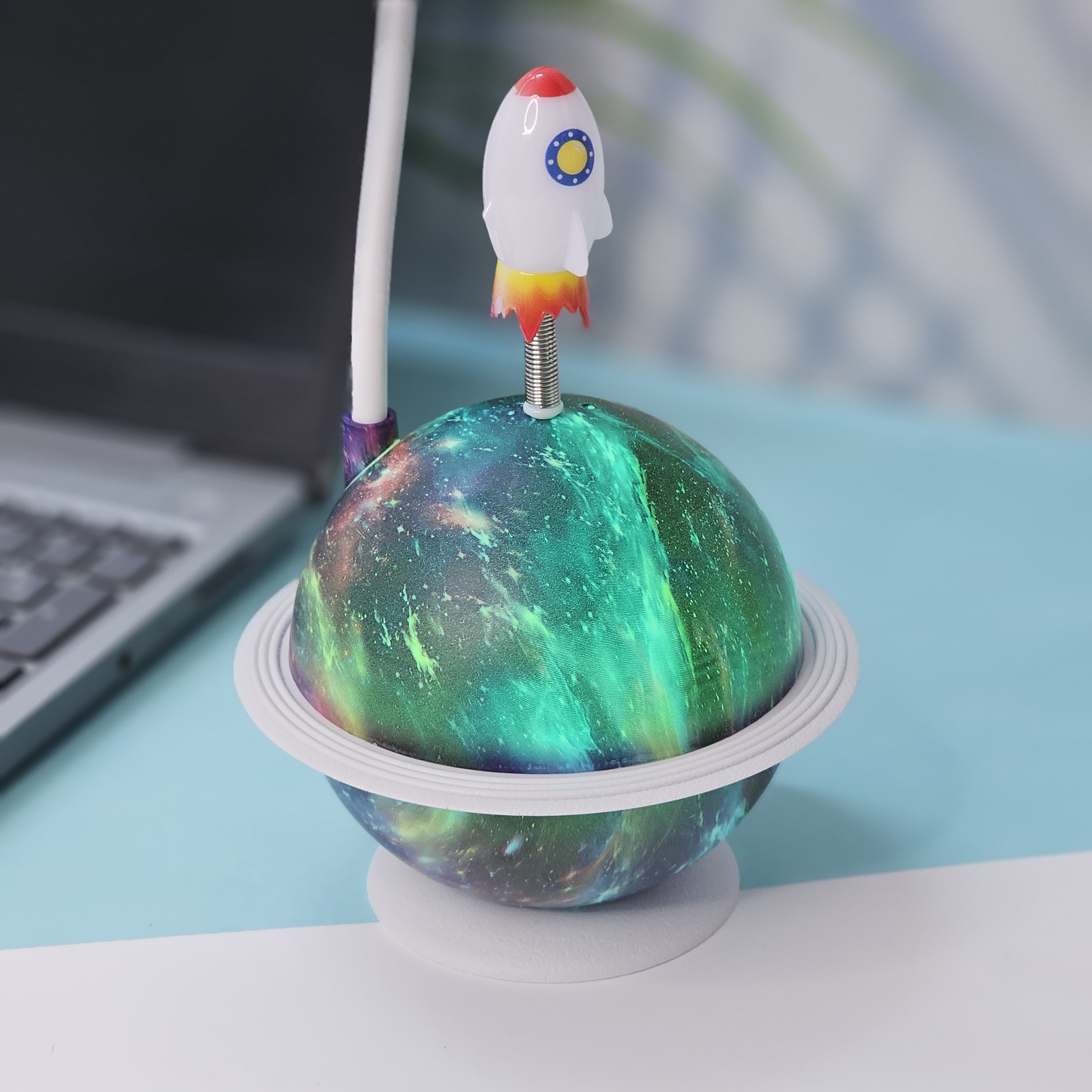 Interactive space-themed lamp for kids: a Usmile Toys astronaut figure attached to a vibrant, illuminated planet base, bringing a celestial glow to any desk." www.usmile.toys
