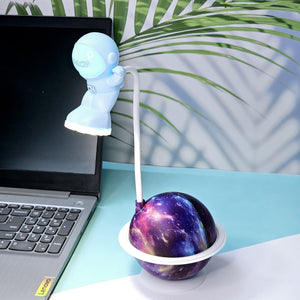 Interactive space-themed lamp for kids: a Usmile Toys astronaut figure attached to a vibrant, illuminated planet base, bringing a celestial glow to any desk."