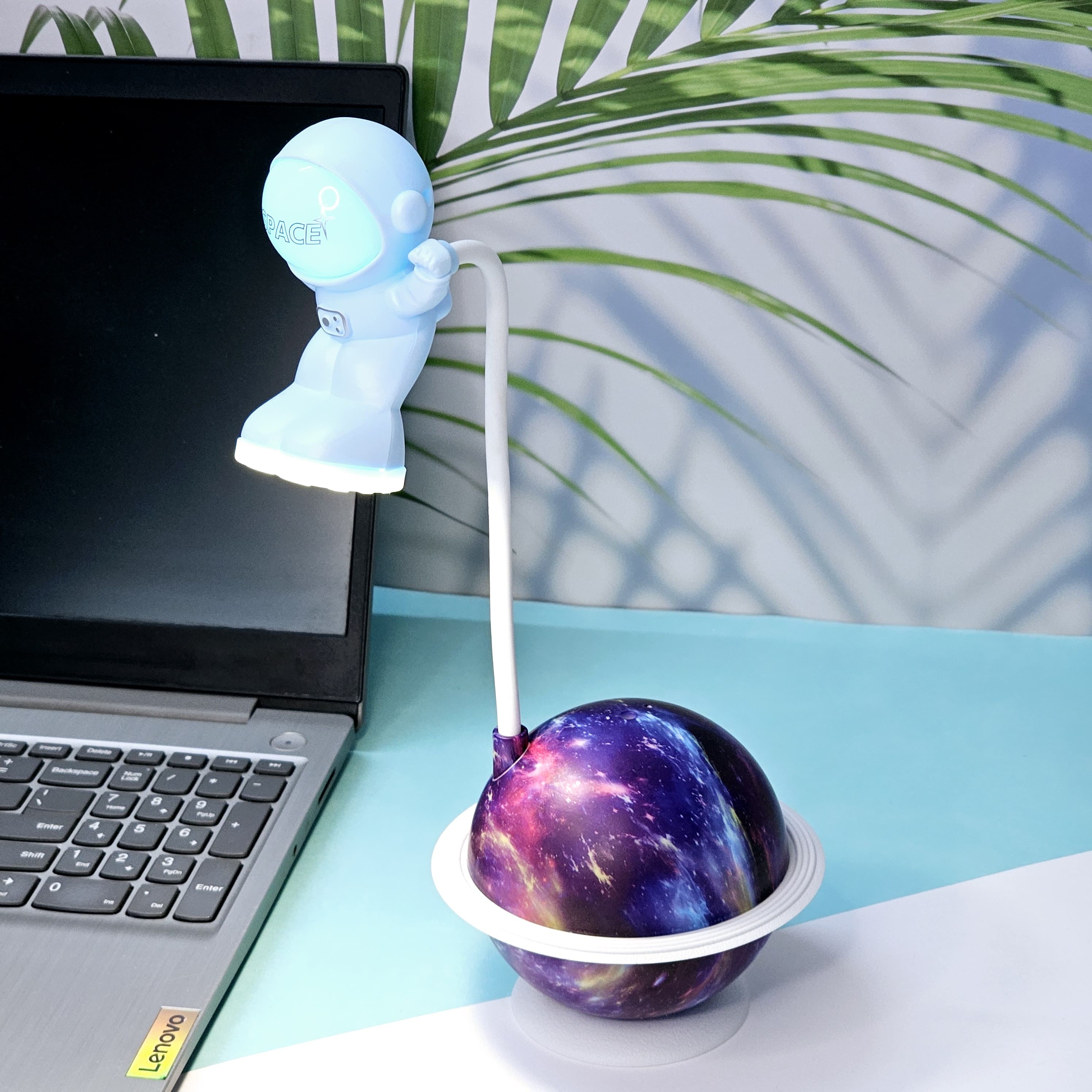 Interactive space-themed lamp for kids: a Usmile Toys astronaut figure attached to a vibrant, illuminated planet base, bringing a celestial glow to any desk."