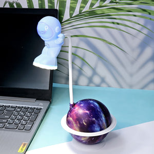 Interactive space-themed lamp for kids: a Usmile Toys astronaut figure attached to a vibrant, illuminated planet base, bringing a celestial glow to any desk."