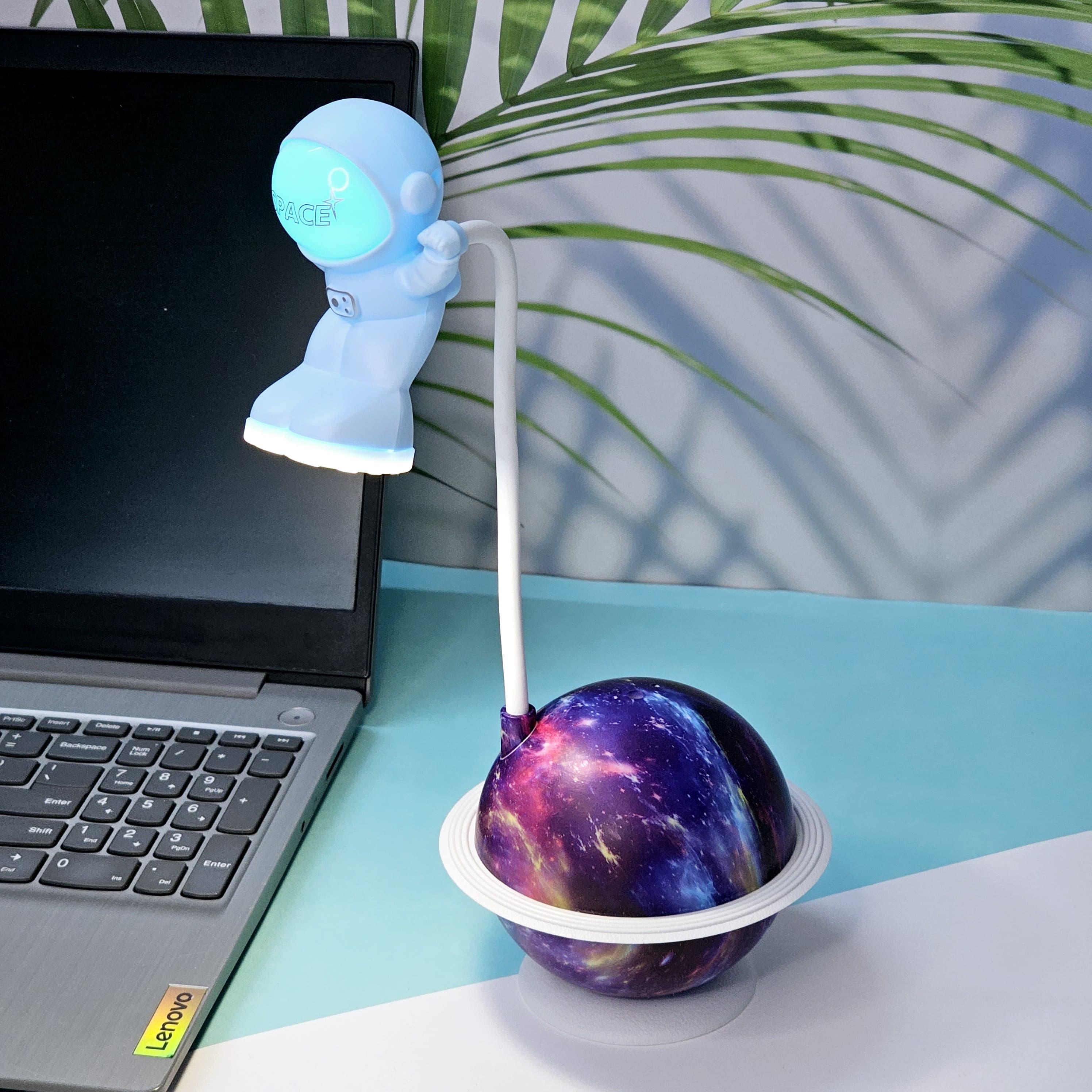 Interactive space-themed lamp for kids: a Usmile Toys astronaut figure attached to a vibrant, illuminated planet base, bringing a celestial glow to any desk."