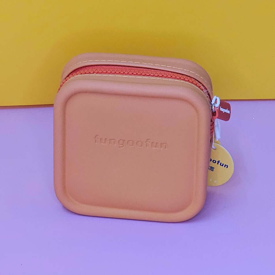 Pink square pouch with zipper on a purple and yellow background