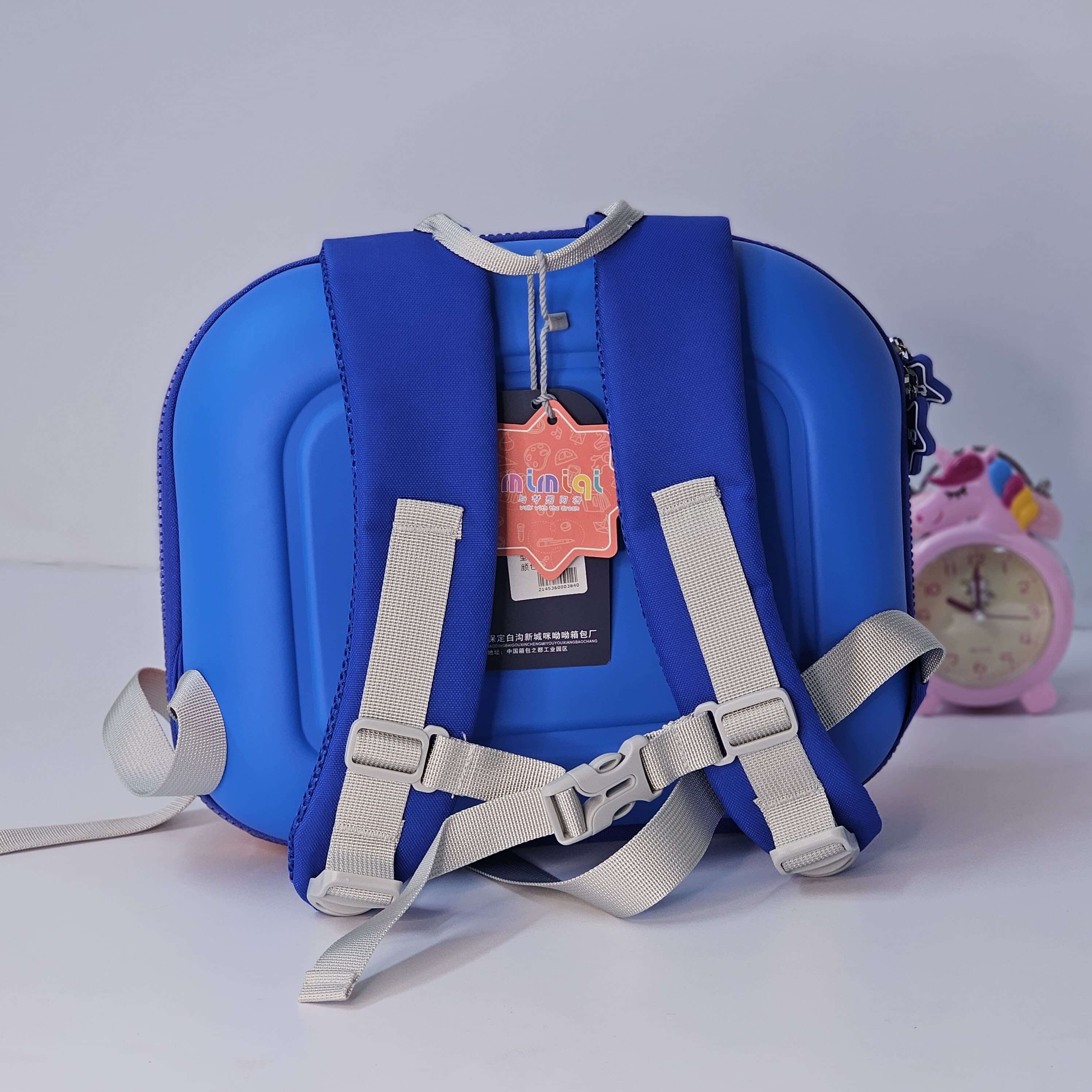 Blue children's backpack with a tag on a light gray background