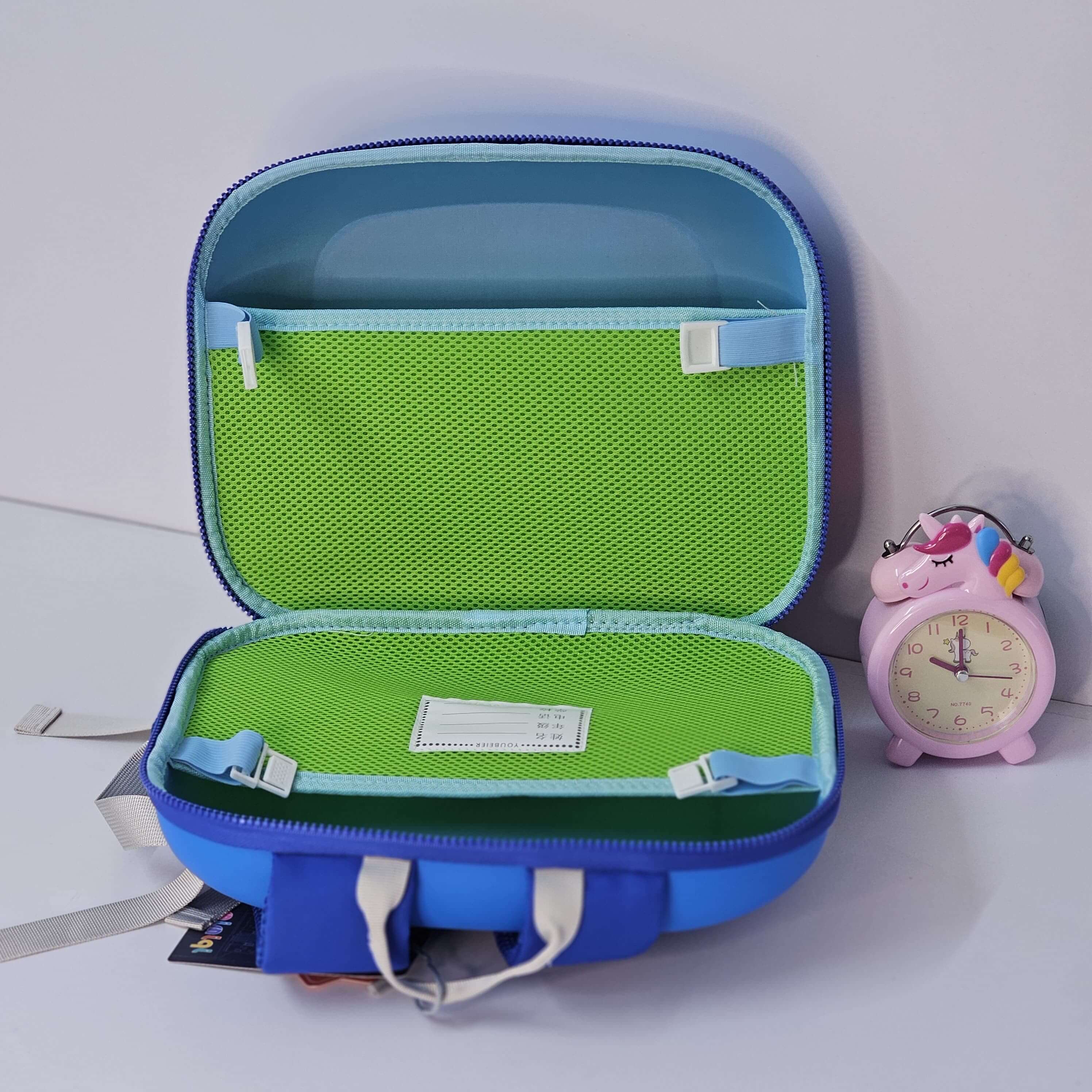 Blue and green open suitcase with a pink clock on a white background