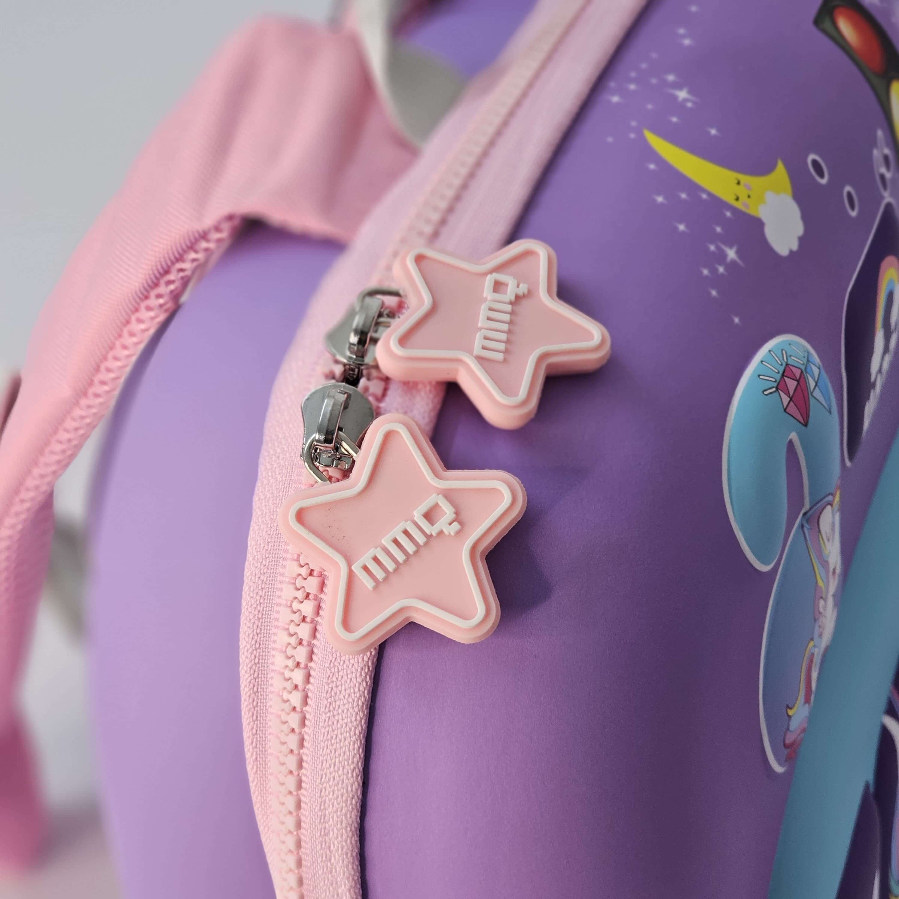 Close-up of a purple bag with pink star-shaped zipper pulls and cartoon designs.