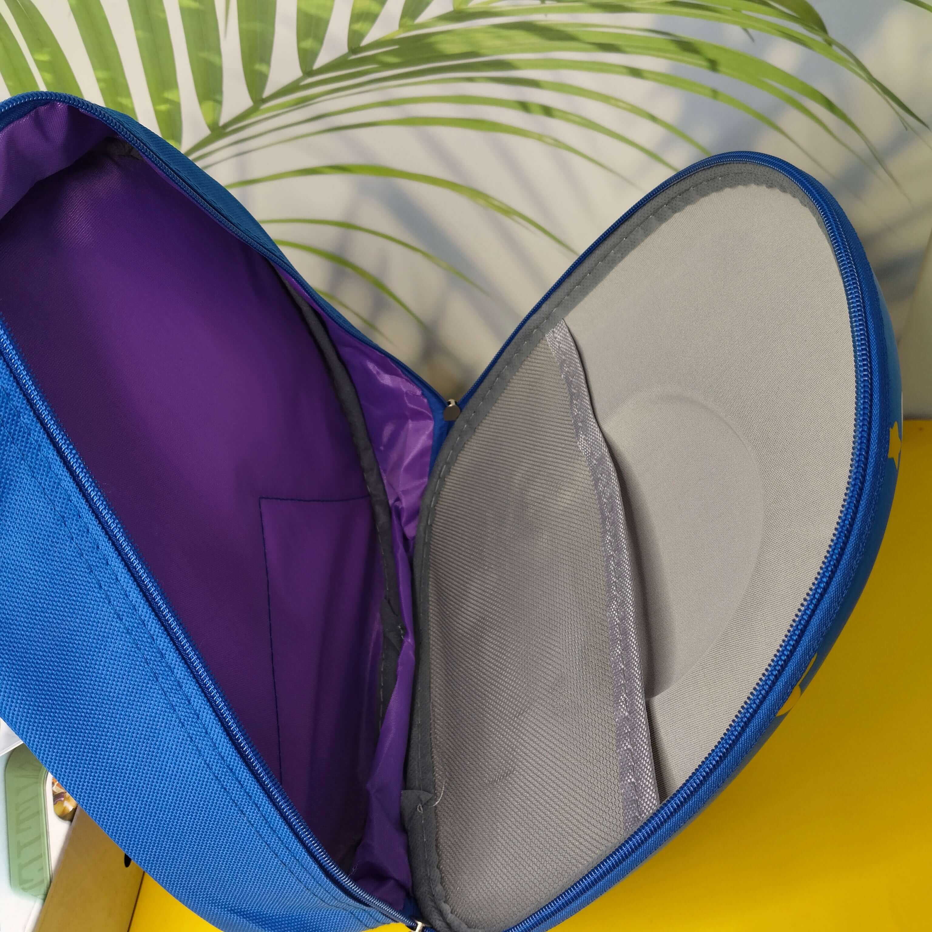 Open blue bag with purple interior on a yellow surface