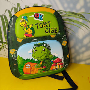 Children's backpack with turtle design and 'OK Tort Oise' text on a yellow surface.