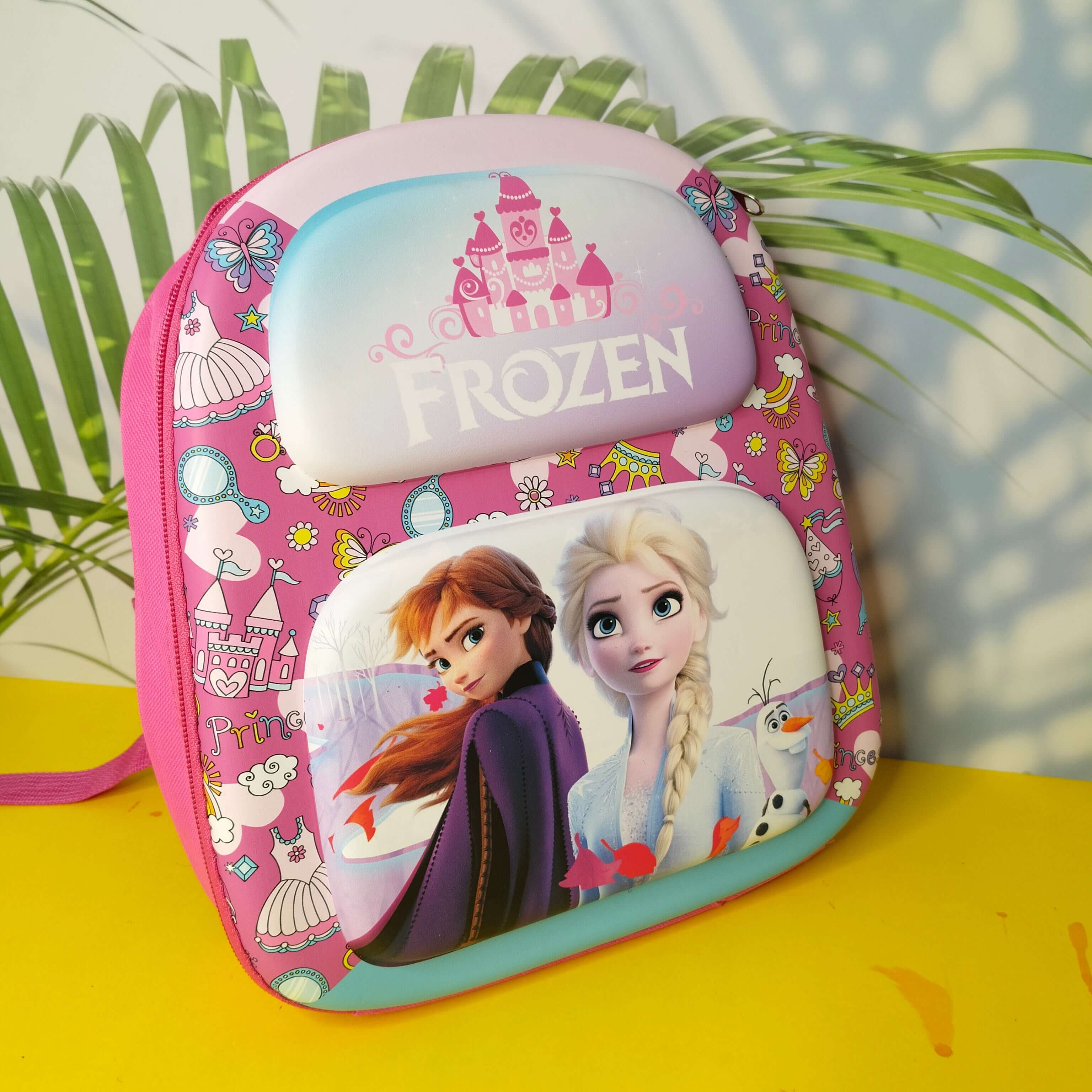 Pink 'Frozen' themed lunch bag with characters on a yellow surface