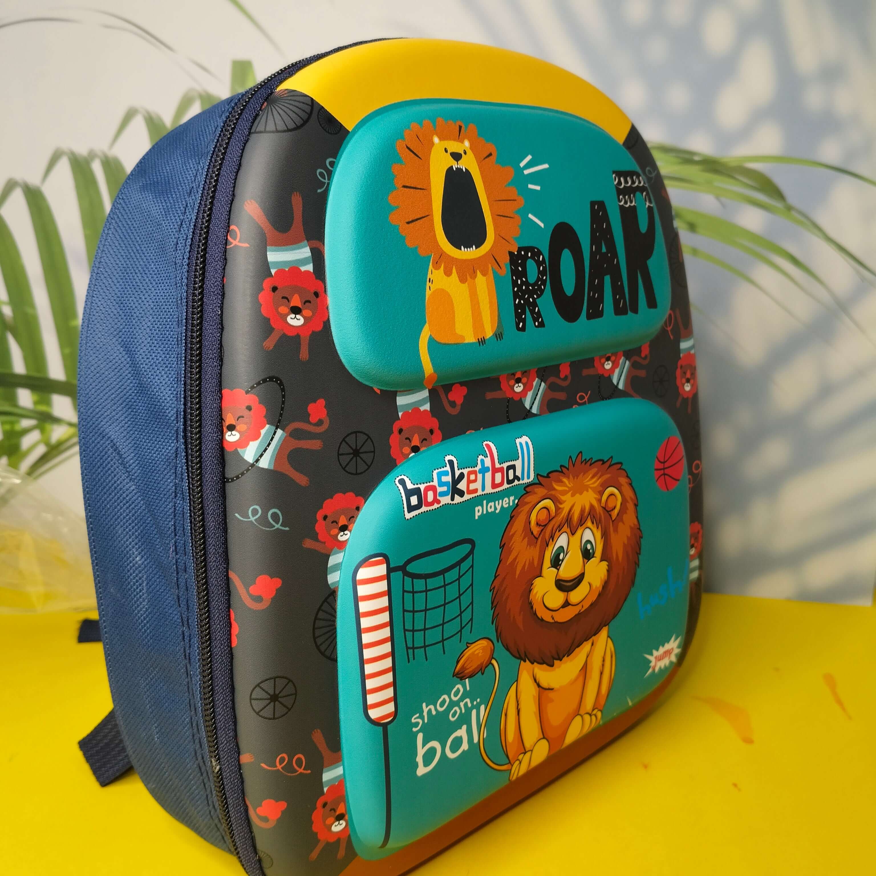 Children's backpack with lion design and text on a yellow surface