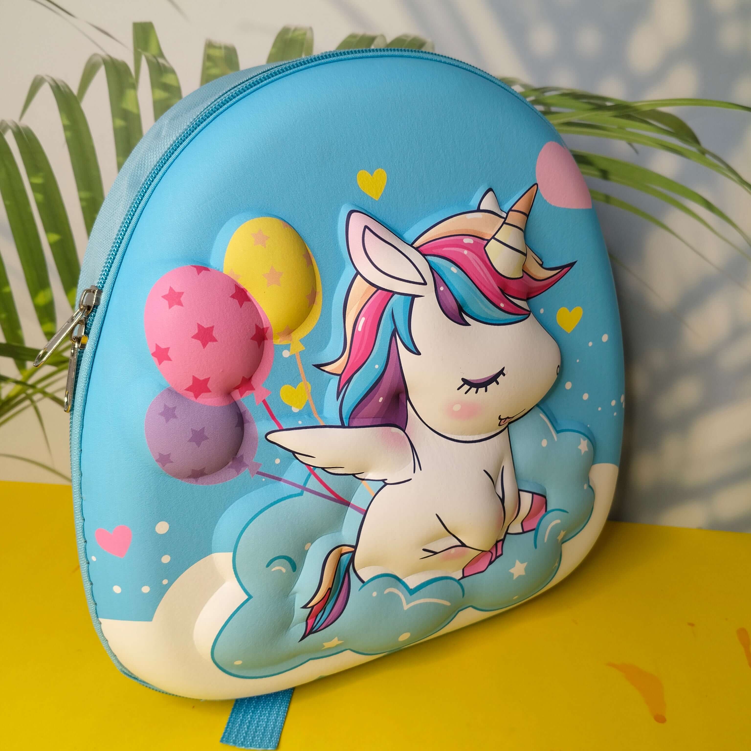 Children's backpack with a unicorn design on a yellow surface with plants in the background