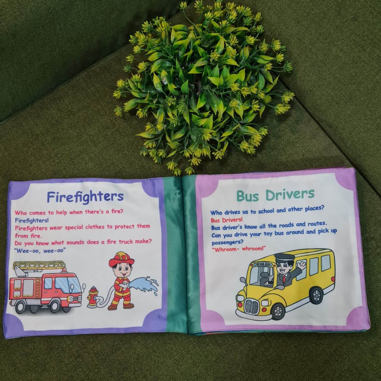 An open "Our Helping Heroes" fabric book by Kidogen, displaying pages about "Police Officers" and "Doctors and Nurses" with illustrations of community helpers and descriptive text.