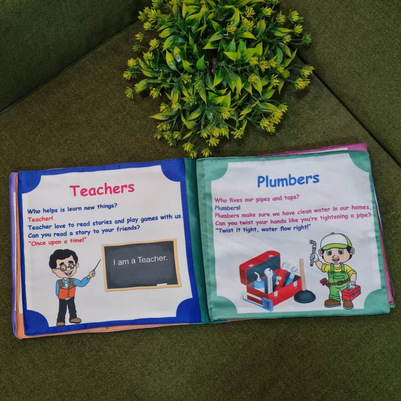 An open "Our Helping Heroes" fabric book by Kidogen, displaying pages about "Police Officers" and "Doctors and Nurses" with illustrations of community helpers and descriptive text.