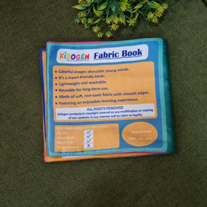 Our Helping Heroes" fabric book by Kidogen, featuring illustrations of a teacher, a farmer, a soldier, a fire truck, and a military vehicle, with the brand logo.