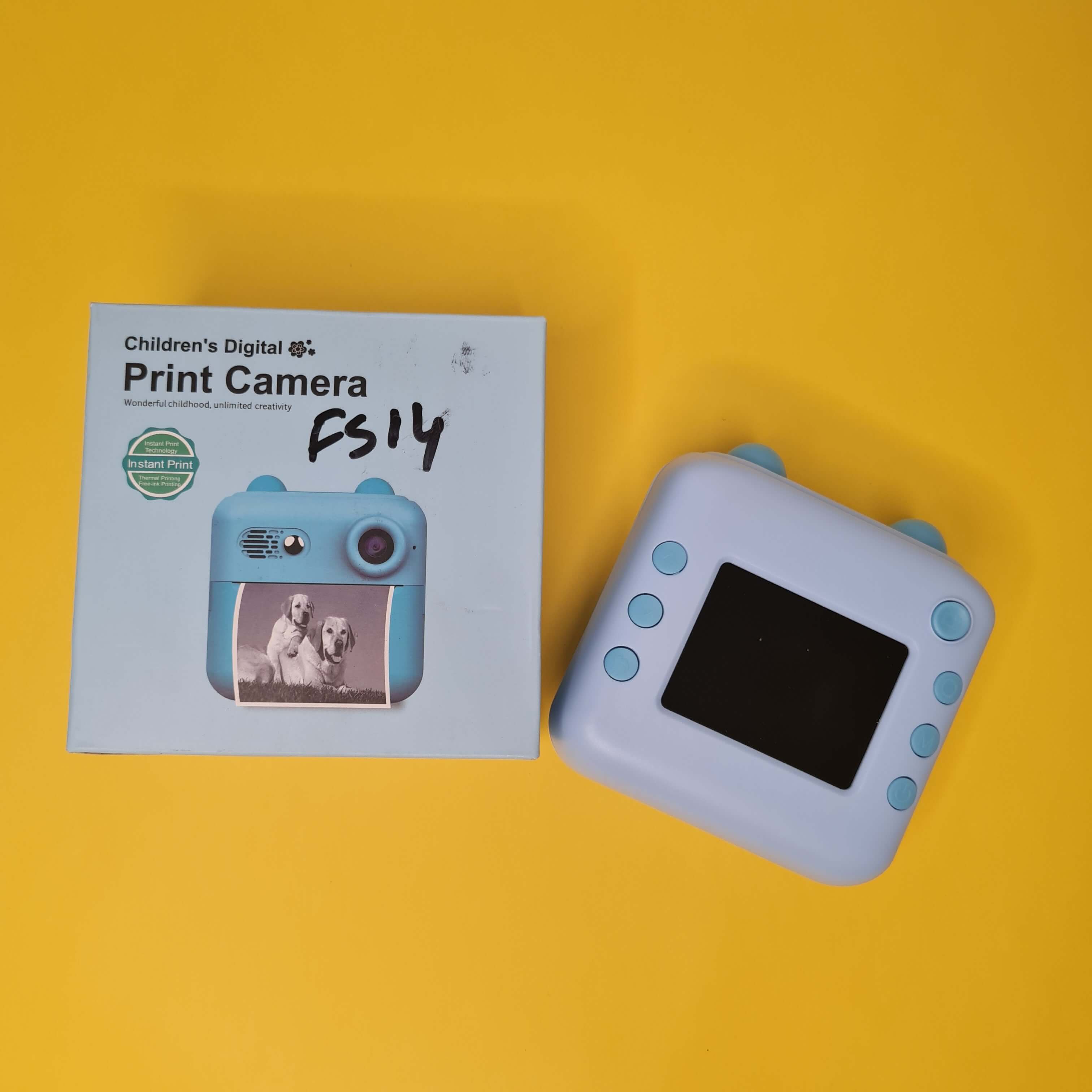 Children's HD Digital Print Camera FS14 in light blue, featuring instant photo printing. The image shows the camera alongside its retail box, ideal for young photographers. www.usmile.toys
