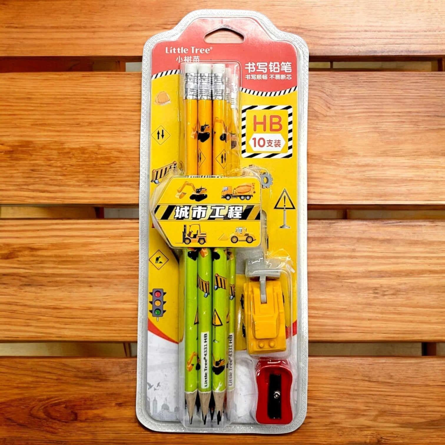 "Usmile Toys Cartoon Theme Kids' Stationery Kit in clear packaging, featuring wooden HB pencils with construction vehicles, a truck-shaped eraser, and a red sharpener." www.usmile toys