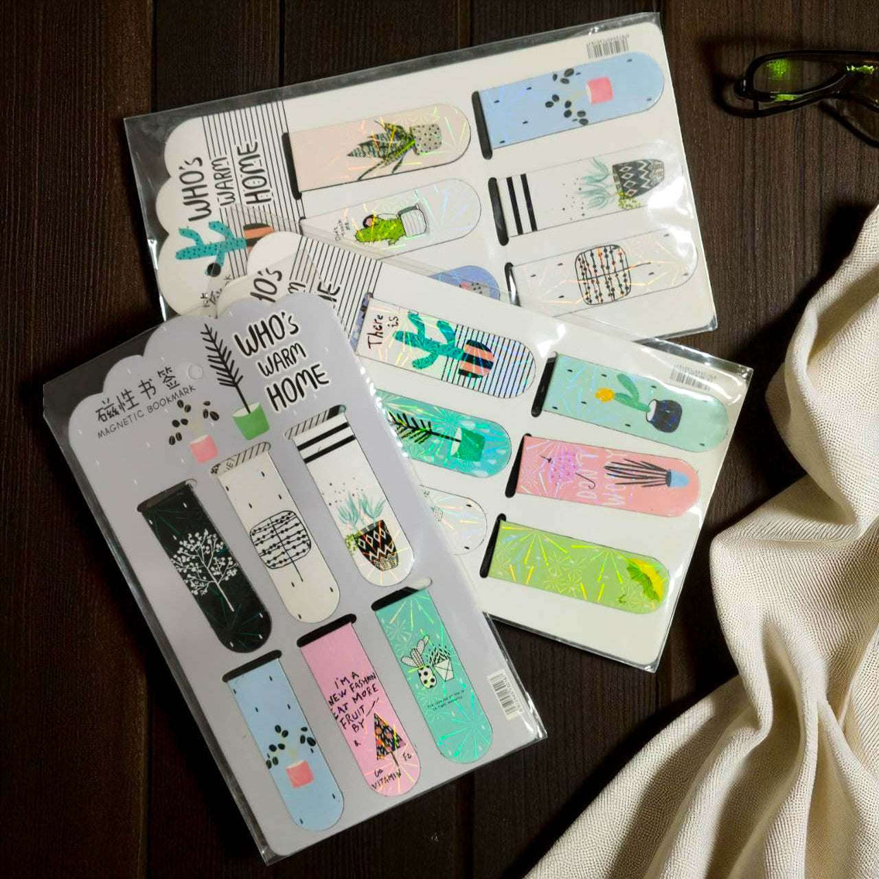 Set of colorful magnetic bookmarks on a wooden surface with a white cloth.
