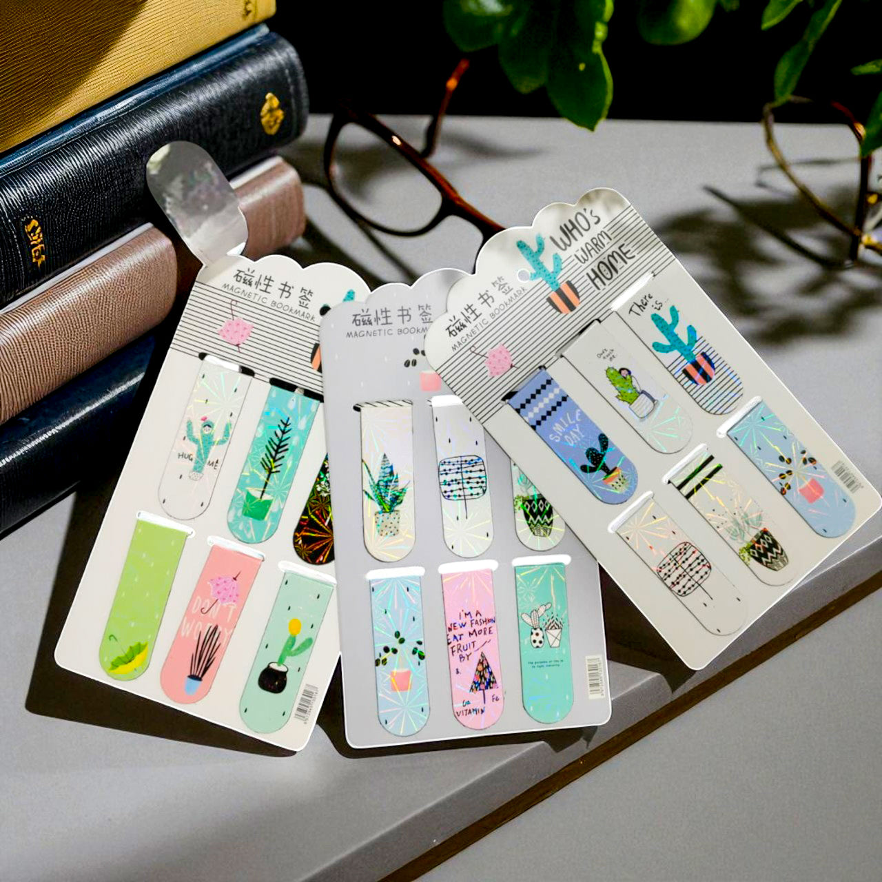 Set of colorful bookmarks on a gray surface with books and glasses in the background