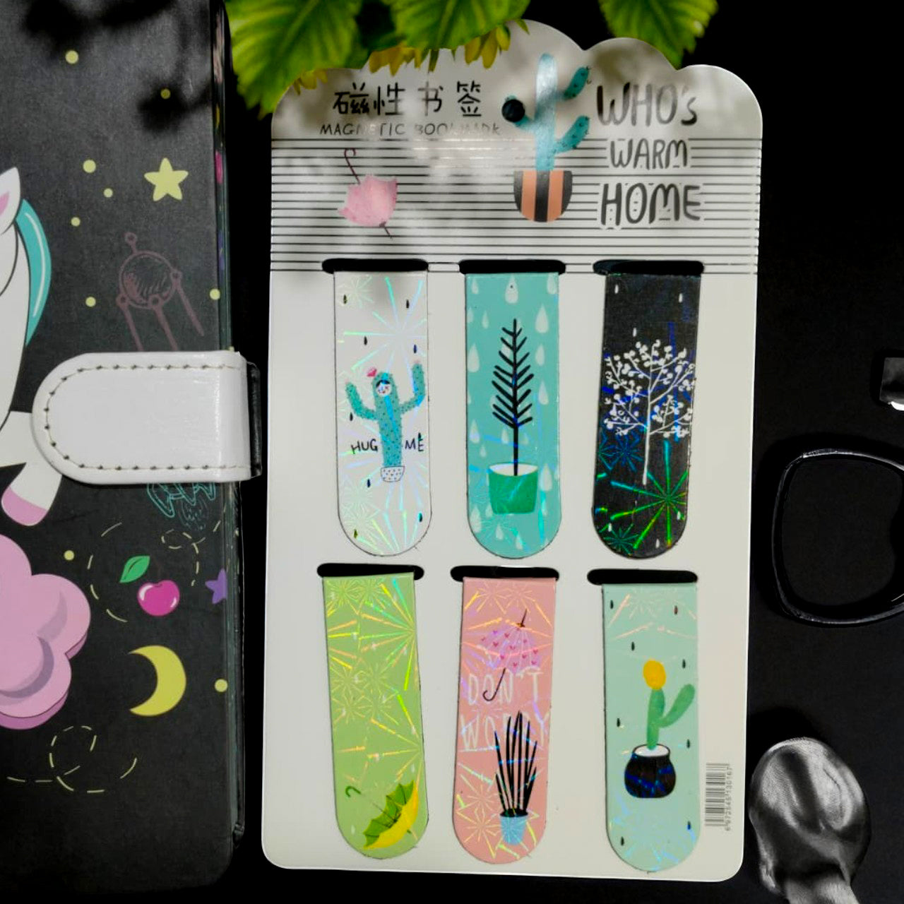 Set of colorful magnetic bookmarks on a card with a black notebook in the background