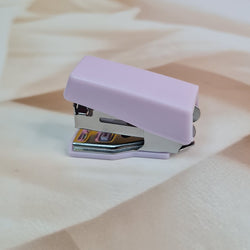 Adorable 9-piece Kawaii mini stationery gift set in pastel purple theme, perfect for school kids and return gift ideas – includes stapler, staple remover, hole puncher, tape holder with tape roll, sharpener, scissor, and a box of staples. Packaged in a beautifully designed cartoon-themed gift box with cute illustrations and soft pink-purple tones. Ideal for girls aged 5 and above who love fun and functional stationery items – available at U Smile Toys India