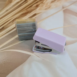 Adorable 9-piece Kawaii mini stationery gift set in pastel purple theme, perfect for school kids and return gift ideas – includes stapler, staple remover, hole puncher, tape holder with tape roll, sharpener, scissor, and a box of staples. Packaged in a beautifully designed cartoon-themed gift box with cute illustrations and soft pink-purple tones. Ideal for girls aged 5 and above who love fun and functional stationery items – available at U Smile Toys India