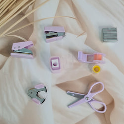 Adorable 9-piece Kawaii mini stationery gift set in pastel purple theme, perfect for school kids and return gift ideas – includes stapler, staple remover, hole puncher, tape holder with tape roll, sharpener, scissor, and a box of staples. Packaged in a beautifully designed cartoon-themed gift box with cute illustrations and soft pink-purple tones. Ideal for girls aged 5 and above who love fun and functional stationery items – available at U Smile Toys India