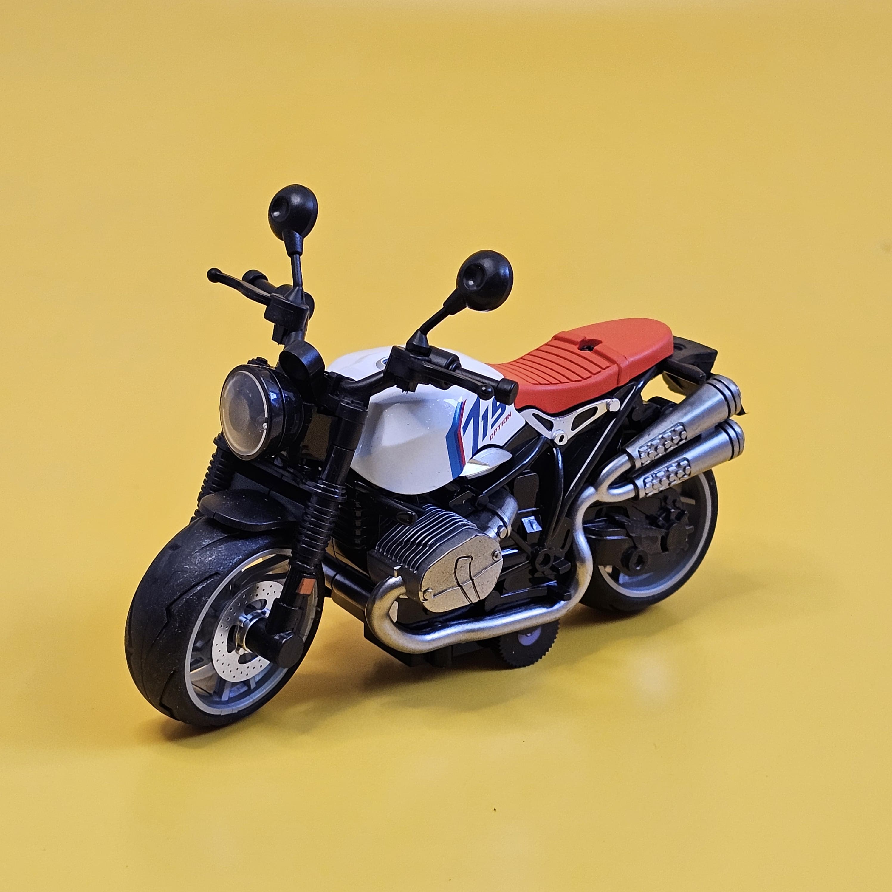 Close-up of a white and black diecast model bike with a red seat, ideal for imaginative play, usmile.toys