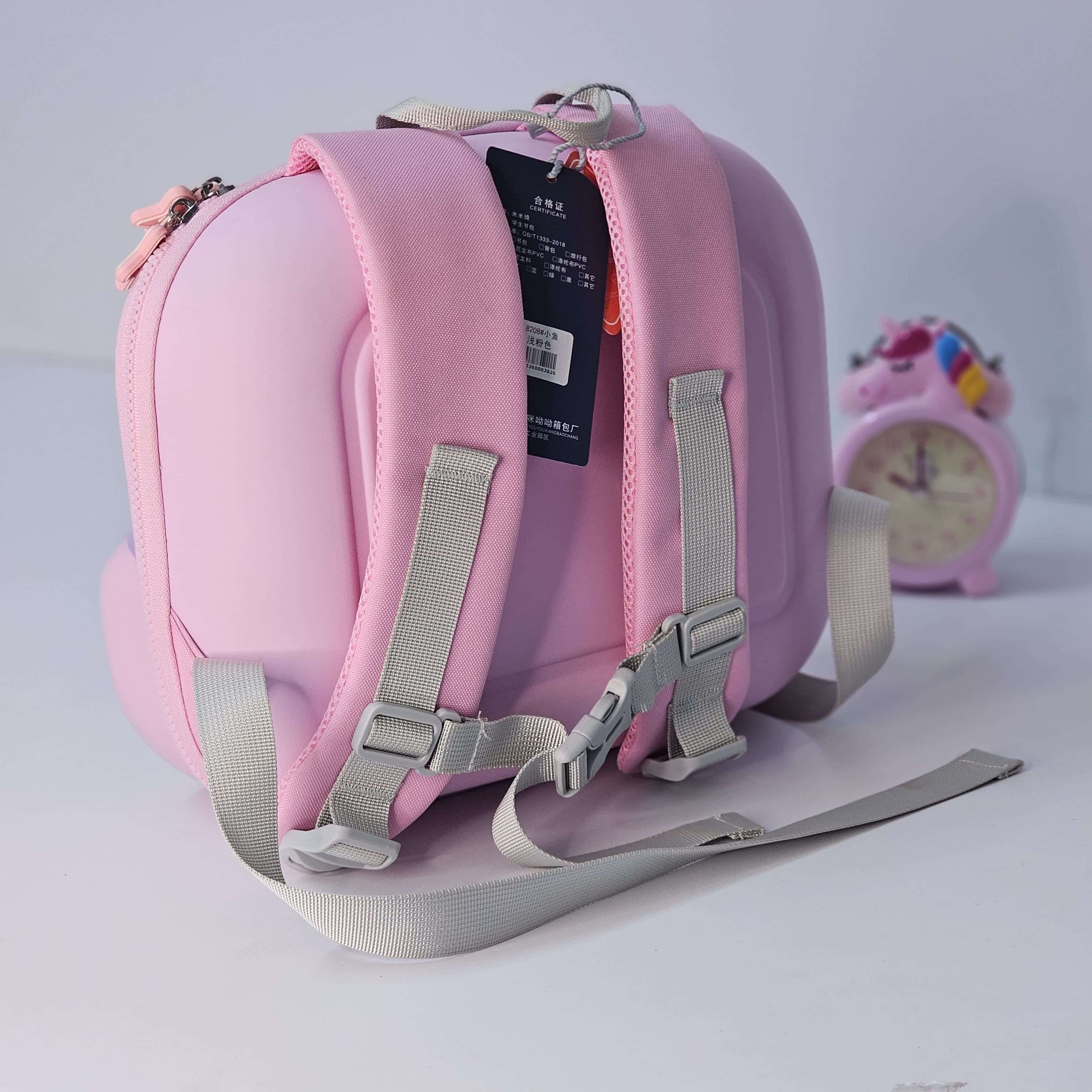 Pink children's backpack with gray straps on a light gray background