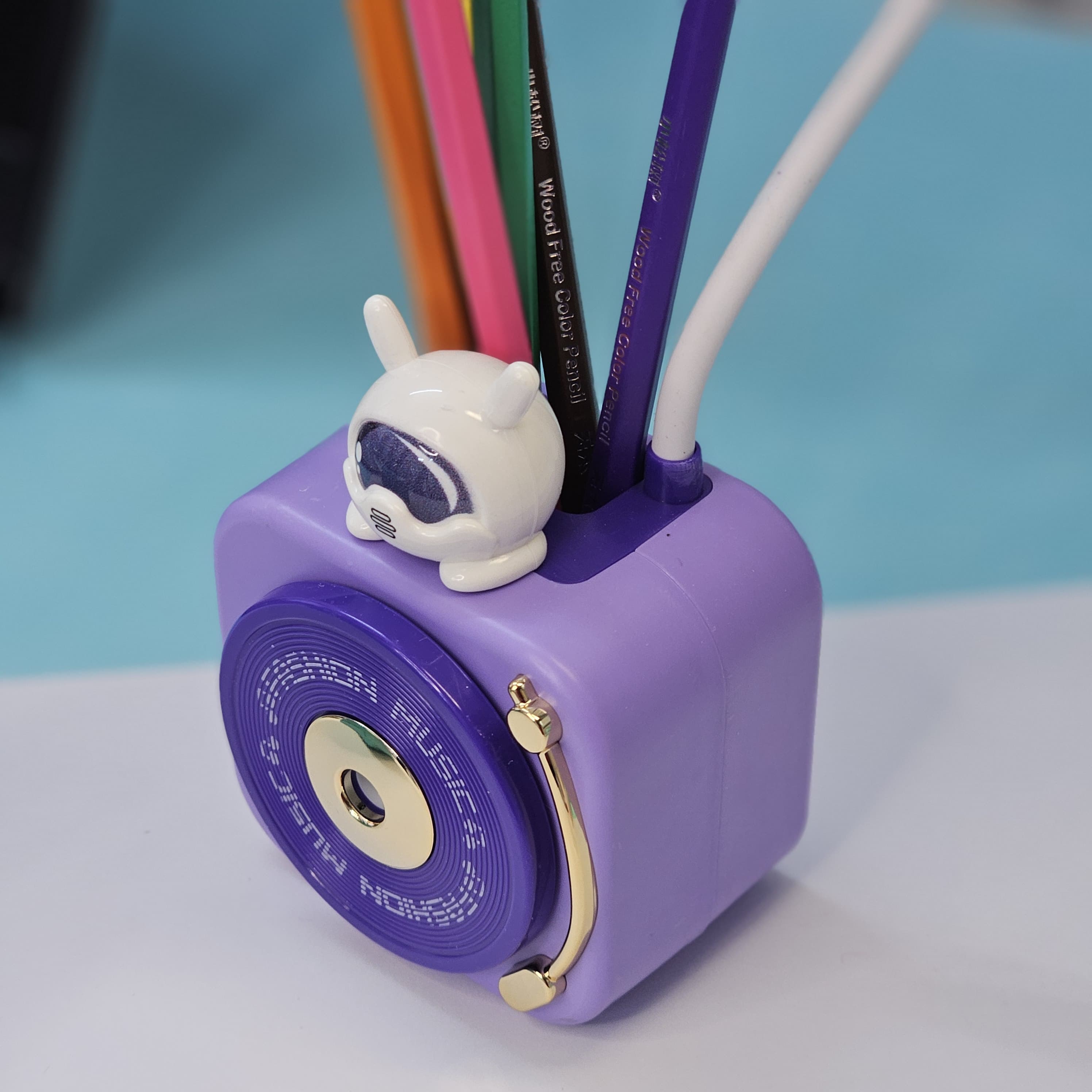 Compact Usmile Toys LED desk lamp with a built-in pencil sharpener and pen holder, perfect for students and kids. This space-saving teal plastic desk light offers bright illumination for reading and drawing, helping children stay organized." www.usmile toys