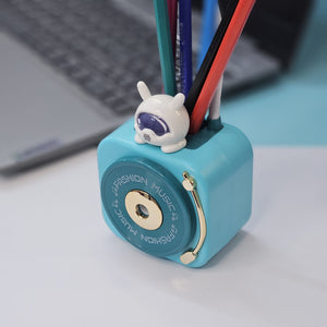 Compact Usmile Toys LED desk lamp with a built-in pencil sharpener and pen holder, perfect for students and kids. This space-saving teal plastic desk light offers bright illumination for reading and drawing, helping children stay organized." www.usmile.toys