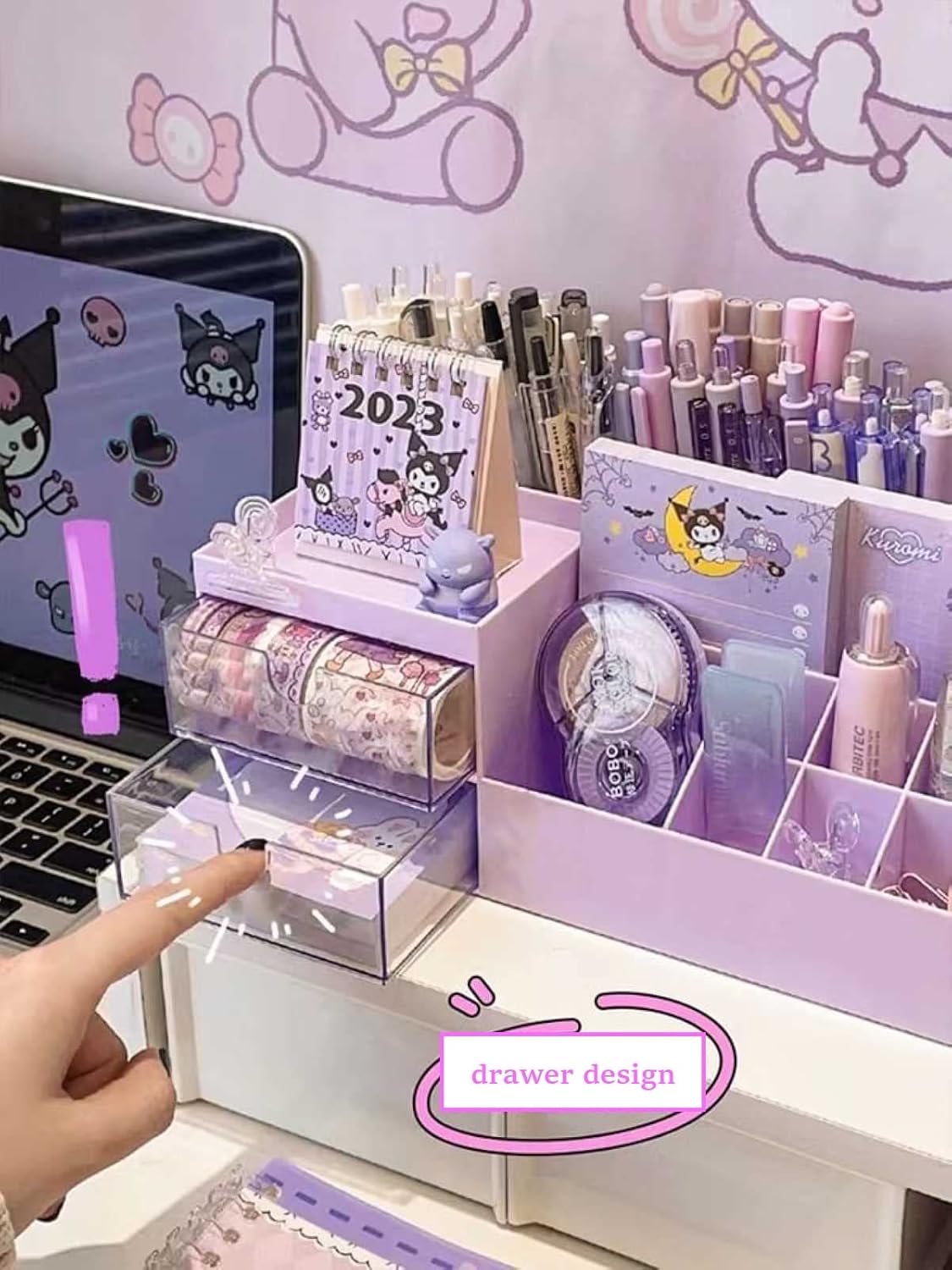 Desk setup with stationery items, a calendar, and a laptop in a room with cartoon decor.