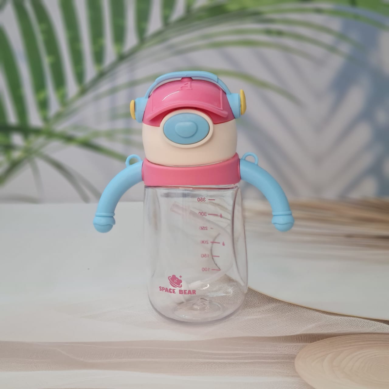 Set of three Space Bear plastic water bottles for kids in blue, red, and pink, each with a straw, handle, and unique bear-themed cap resembling headphones. Ideal sippy cups for toddlers and school children on usmile.toys. www.usmile.toys