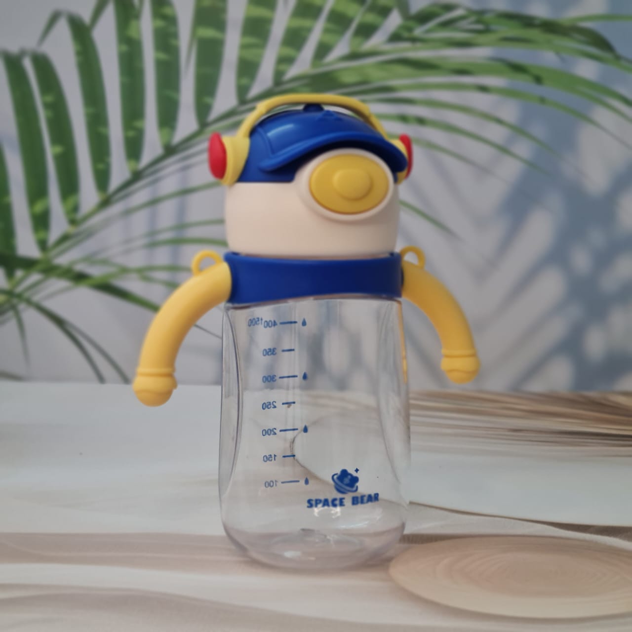 Set of three Space Bear plastic water bottles for kids in blue, red, and pink, each with a straw, handle, and unique bear-themed cap resembling headphones. Ideal sippy cups for toddlers and school children on usmile.toys. www.usmile.toys