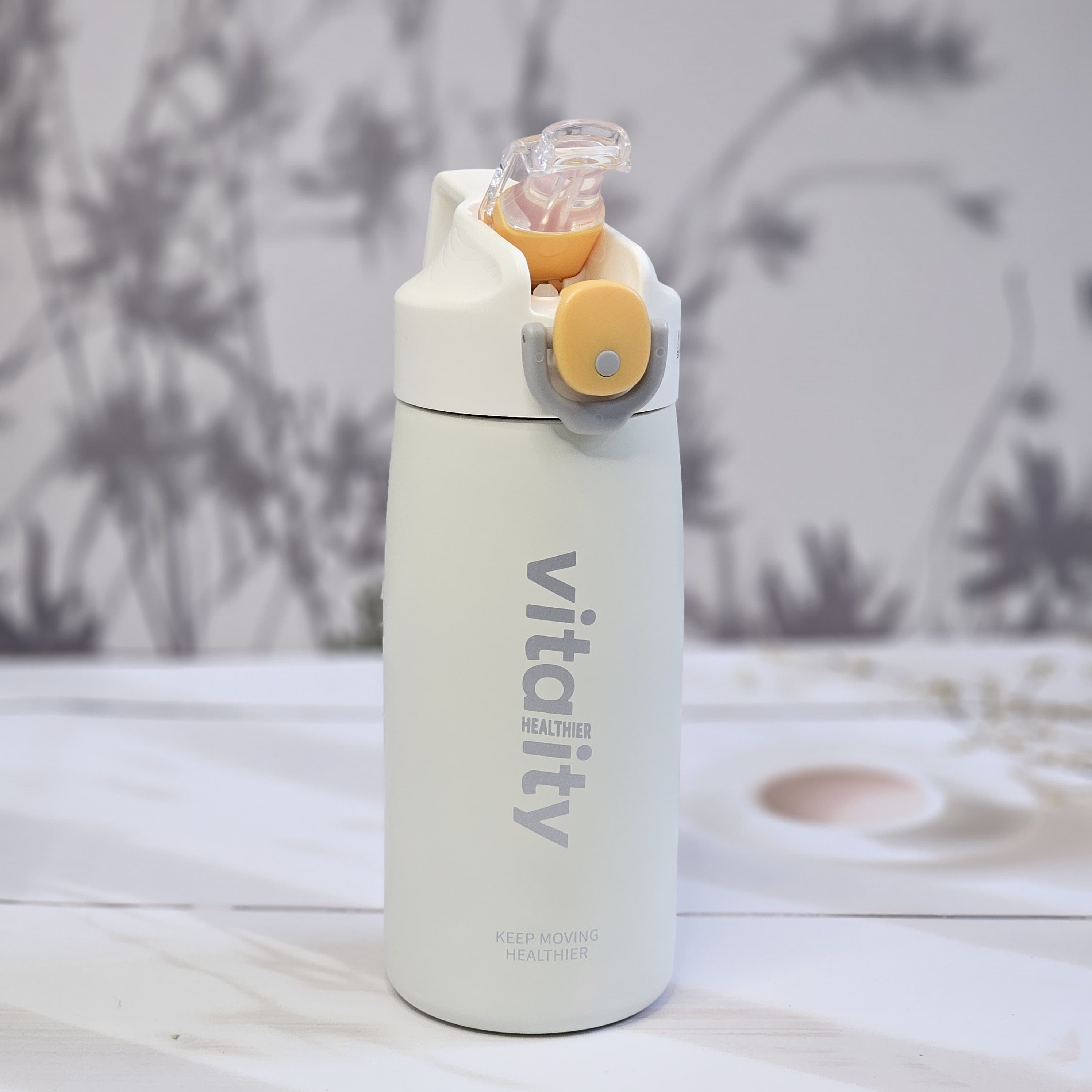 Insulated water bottles for hot and cold drinks, in black, white, and pink, with a flip-top lid and 'vitality' branding.    www.usmile.toys