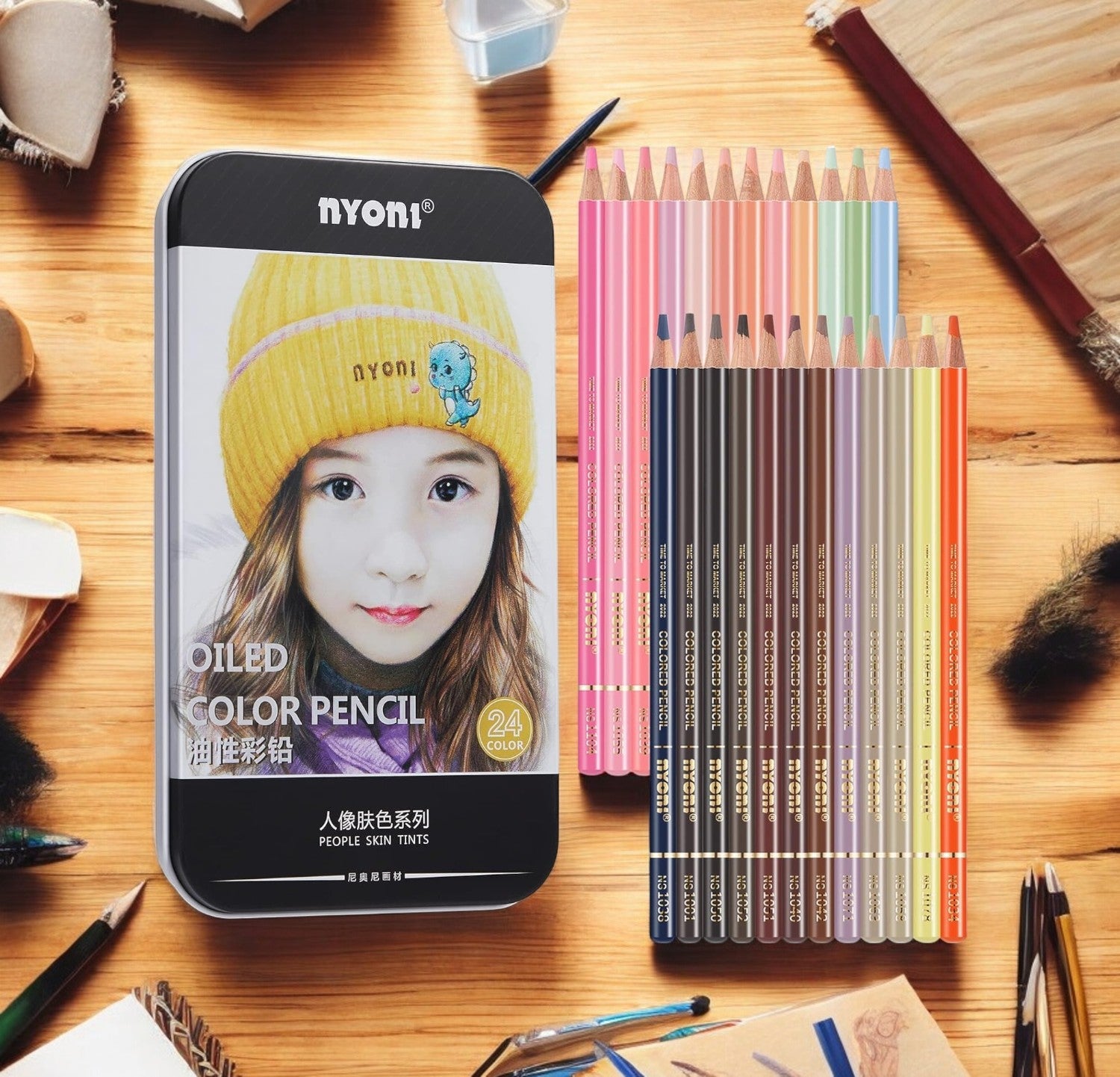 Black metal tin for Nyoni 24-color oiled color pencils, specifically for drawing people skin tints, with pencils fanned out to the side." www.usmile.toys