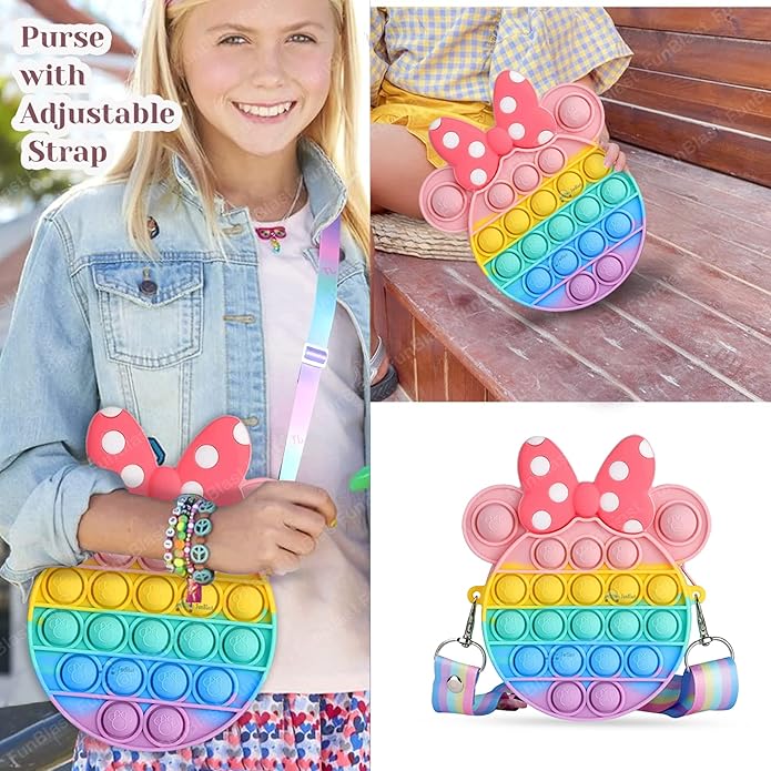 Front view of a Usmile Toys girls' sling bag, designed as a rainbow Pop It fidget toy with a prominent pink Minnie Mouse-style bow and a striped strap." www.usmile.toys