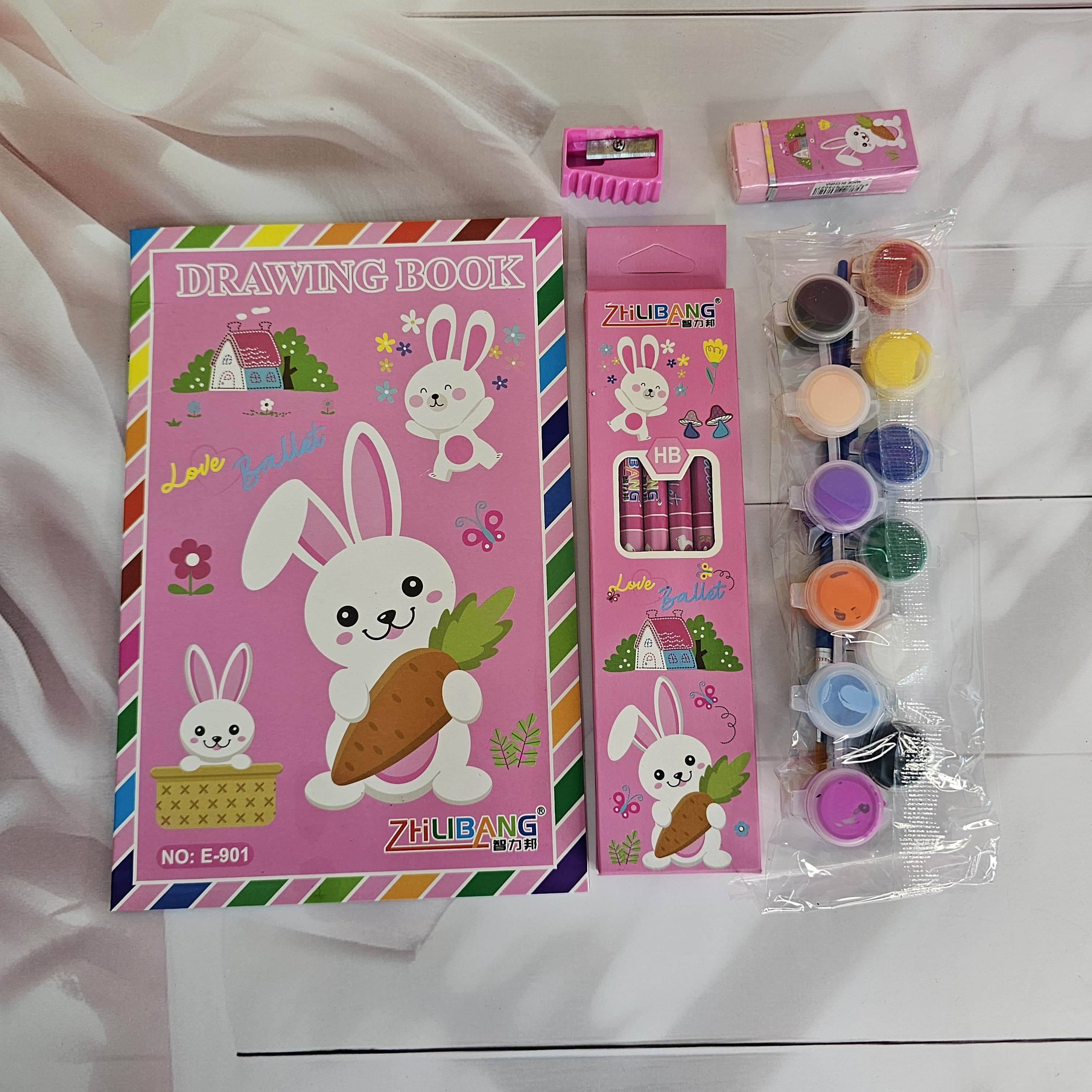 Colorful stationery kit for kids, featuring a dinosaur-themed drawing book and art supplies. www.usmile.toys