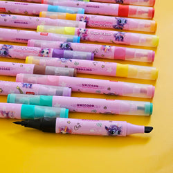 Close-up view of colorful dual-tip unicorn markers laid out on a bright yellow background. These water-based markers, themed "Yoyo & Zozo," feature vibrant ink colors and adorable unicorn illustrations on the barrels. Each marker includes both fine and chisel tips for versatile coloring and drawing. Perfect for kids' art activities, school projects, and gifts, these non-toxic, washable markers are part of a fun and creative kids stationery collection